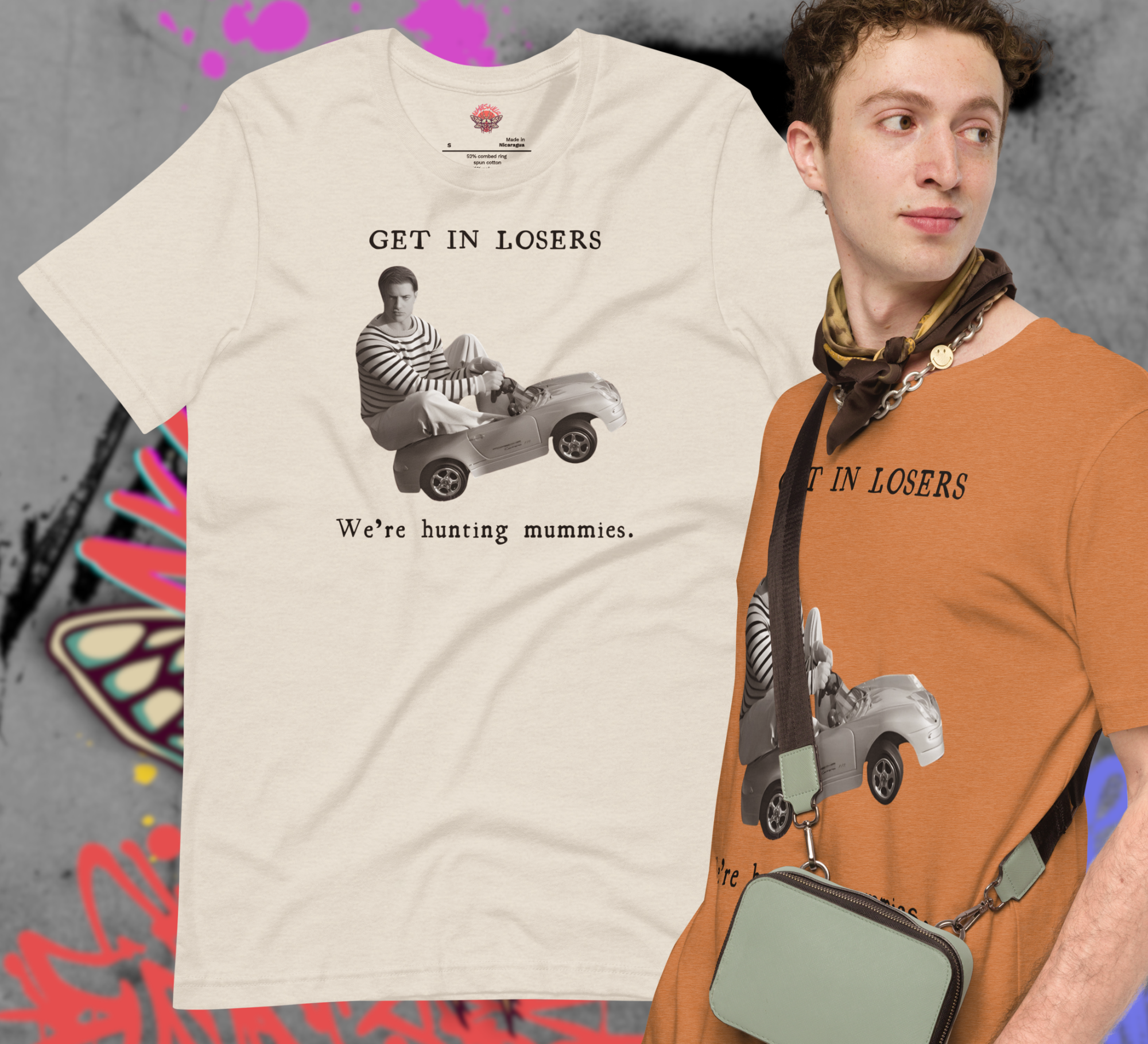 picture of white tee with image of Brendan Frasier in a toy car with text: Get in Losers We're hunting mummies.  A model to the right of the shirt wearing a butterscotch colored version of the shirt.